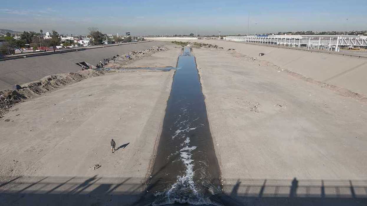The Tijuana river flowing past concrete barriers