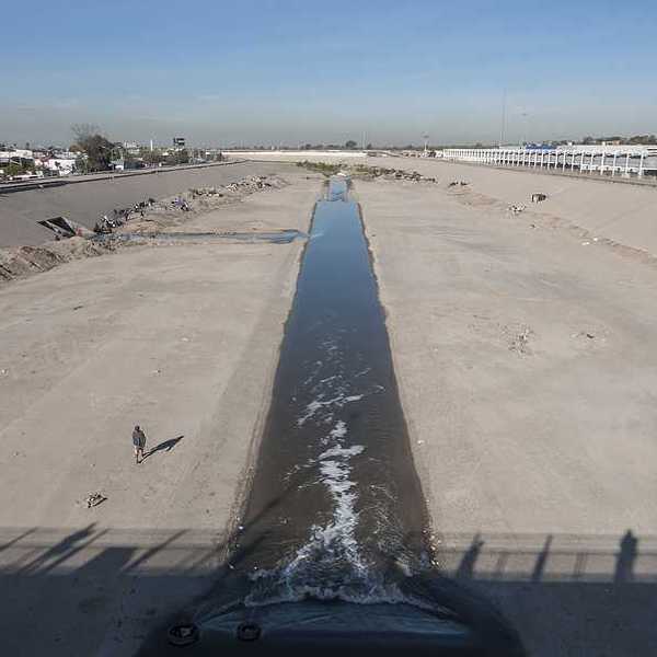 The Tijuana river flowing past concrete barriers