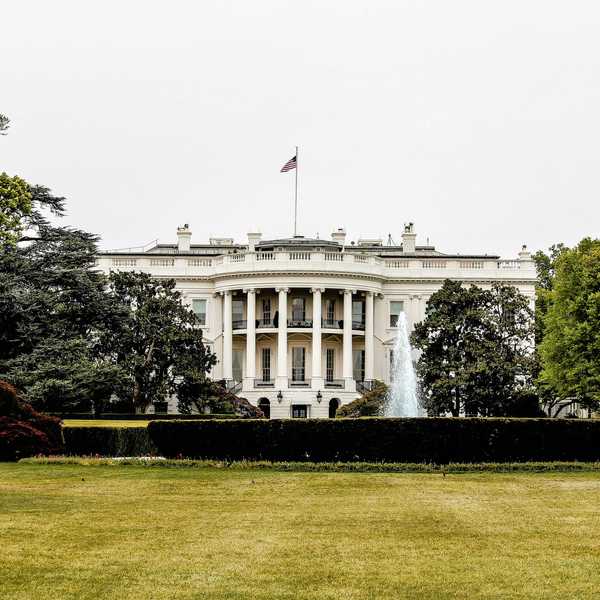 The White House with lawn and trees in foreground.