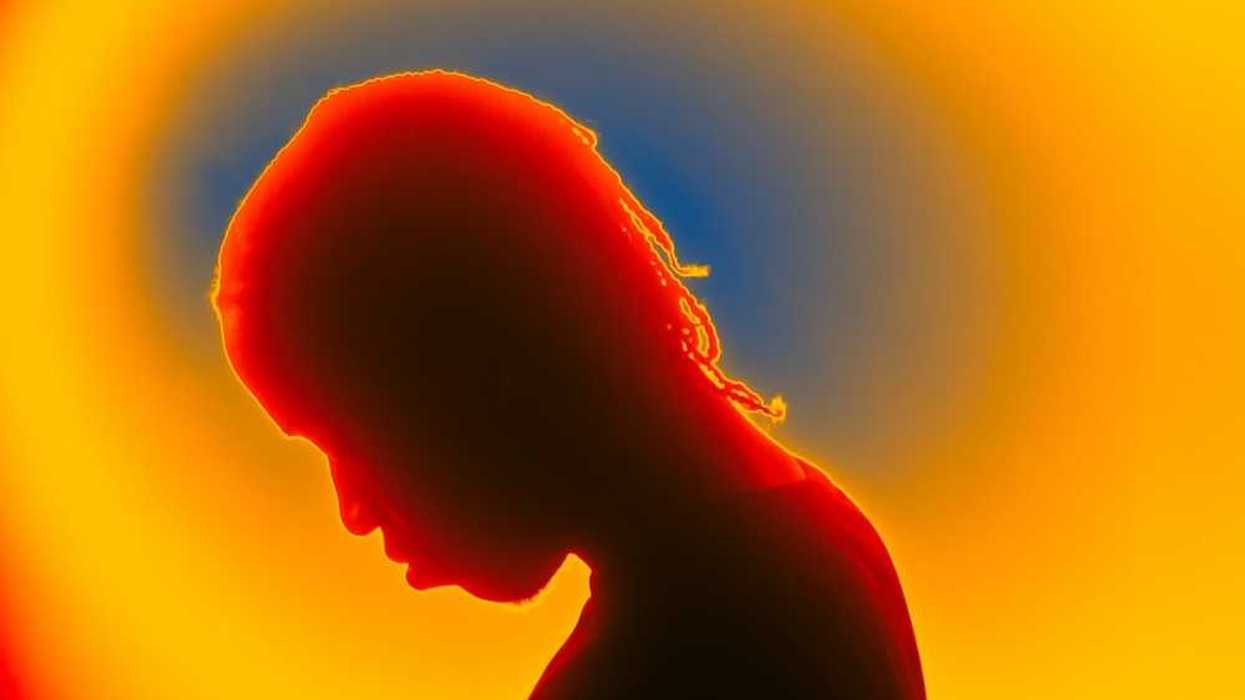 Thermal image of person with bowed head, presumably sad or afflicted with some malady