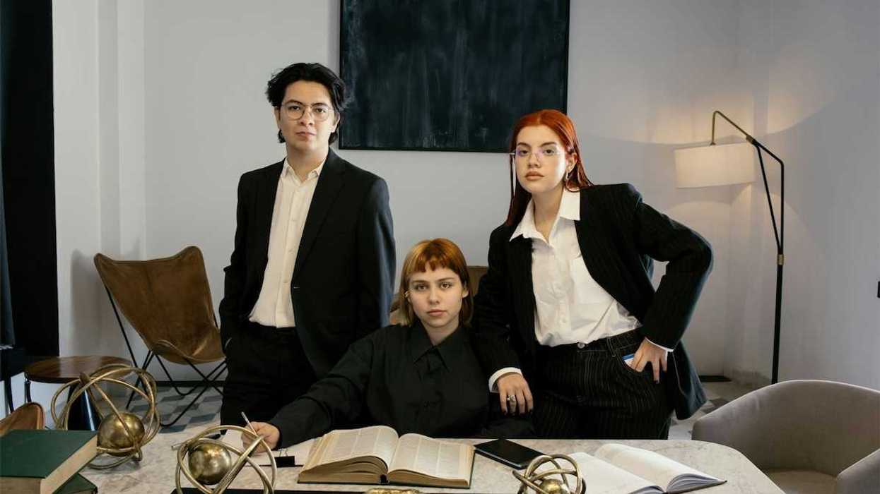 Three attorneys gathered around a desk