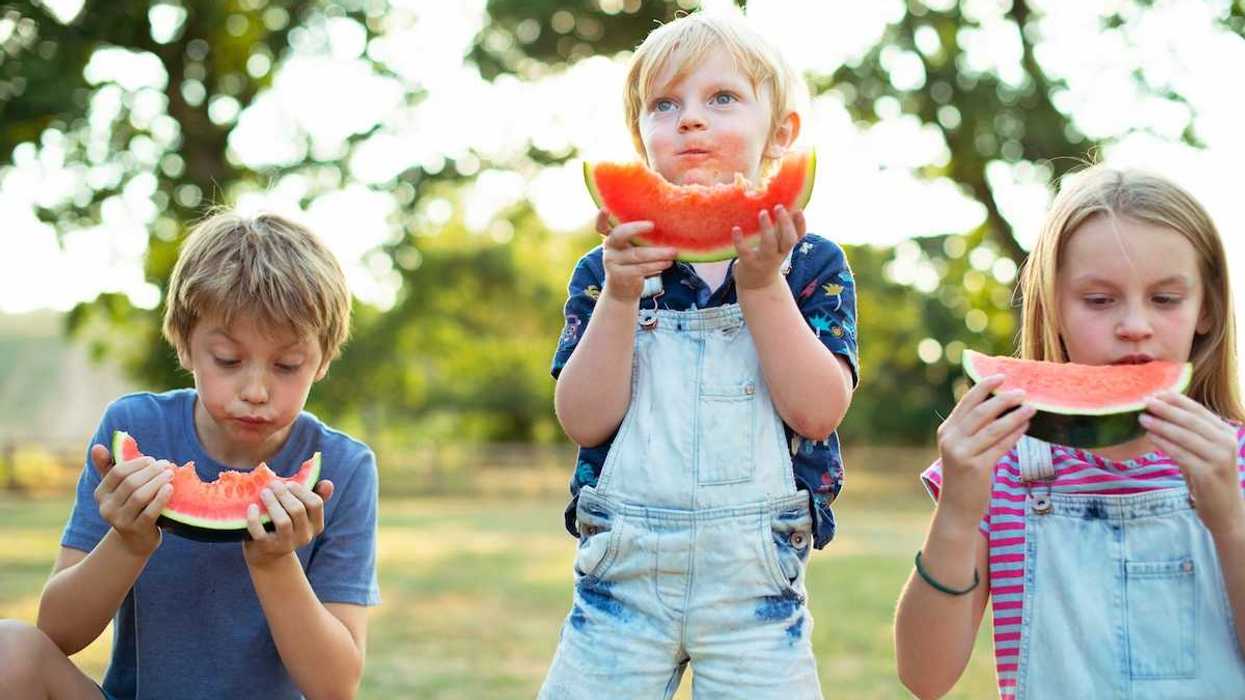 Three children eating watermelon