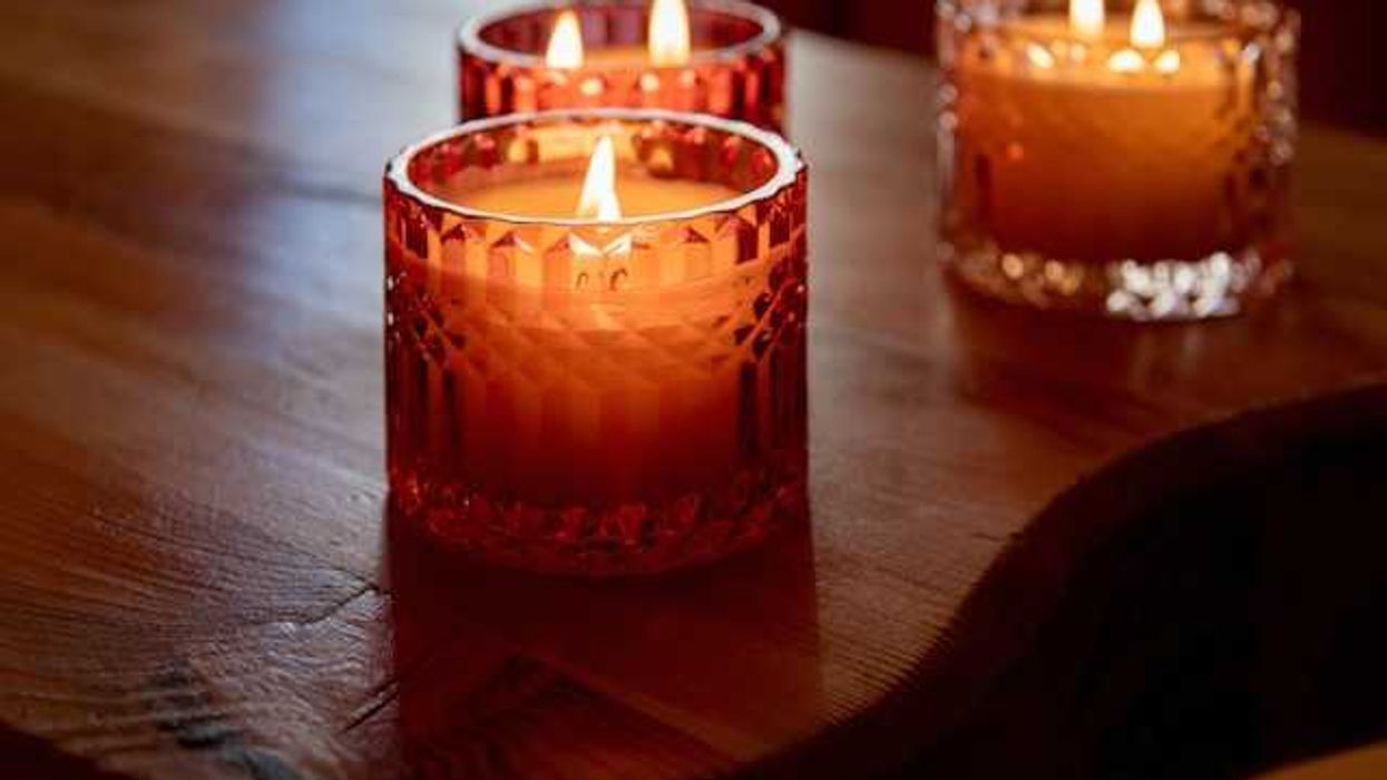 Three lit candles in amber colored glass containers