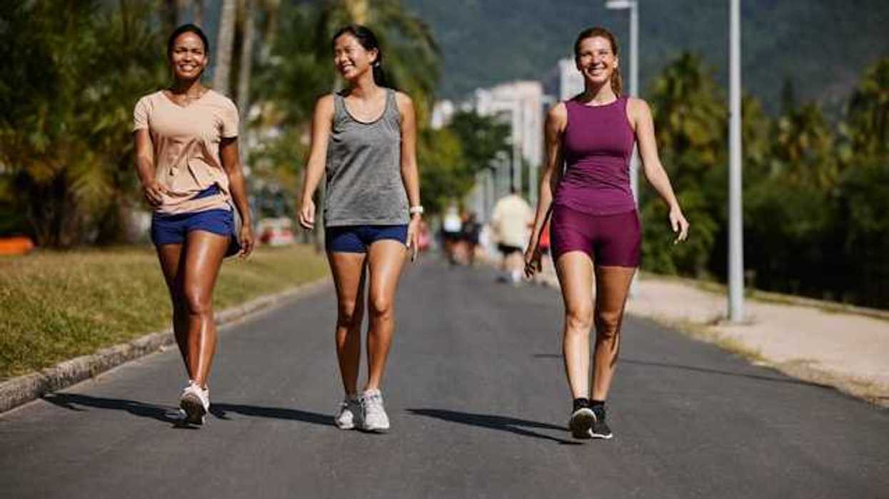 Three women wearing active wear walking on a sunny path