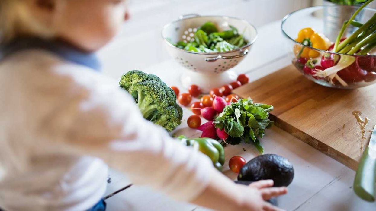 Toddler reaching for fresh fruit and vegetables