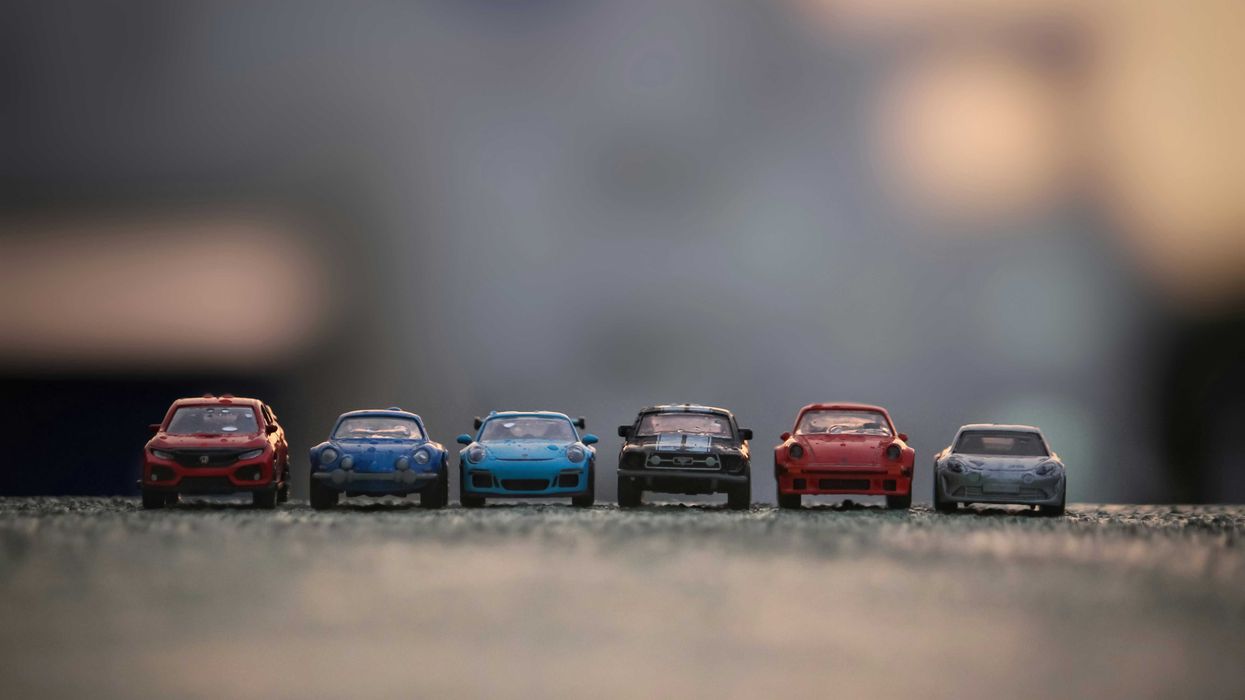 Toy cars lined up on a paved surface