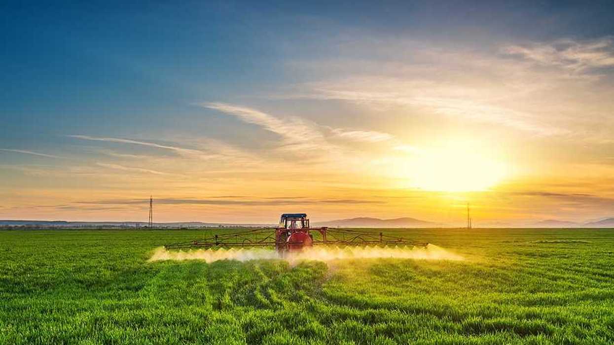 Tractor spray fertilizer spraying pesticides on green field, agriculture background concept.