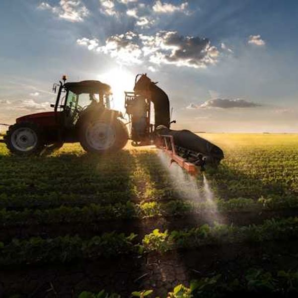 Tractor spraying pesticides on a field