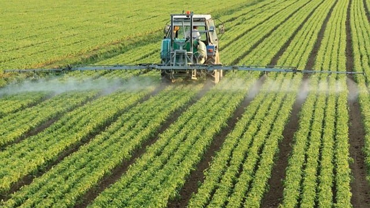 tractor spraying pesticides on crops