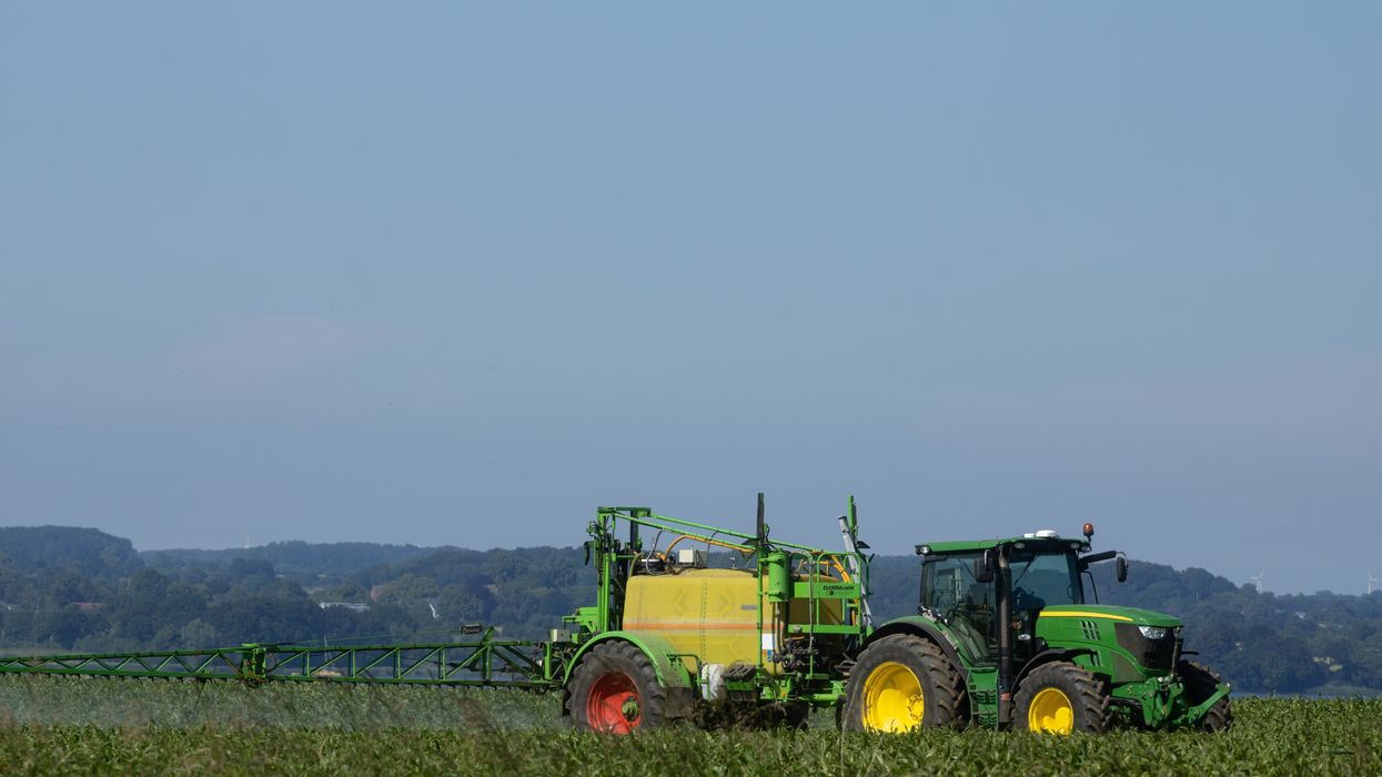tractor spraying pesticides on field