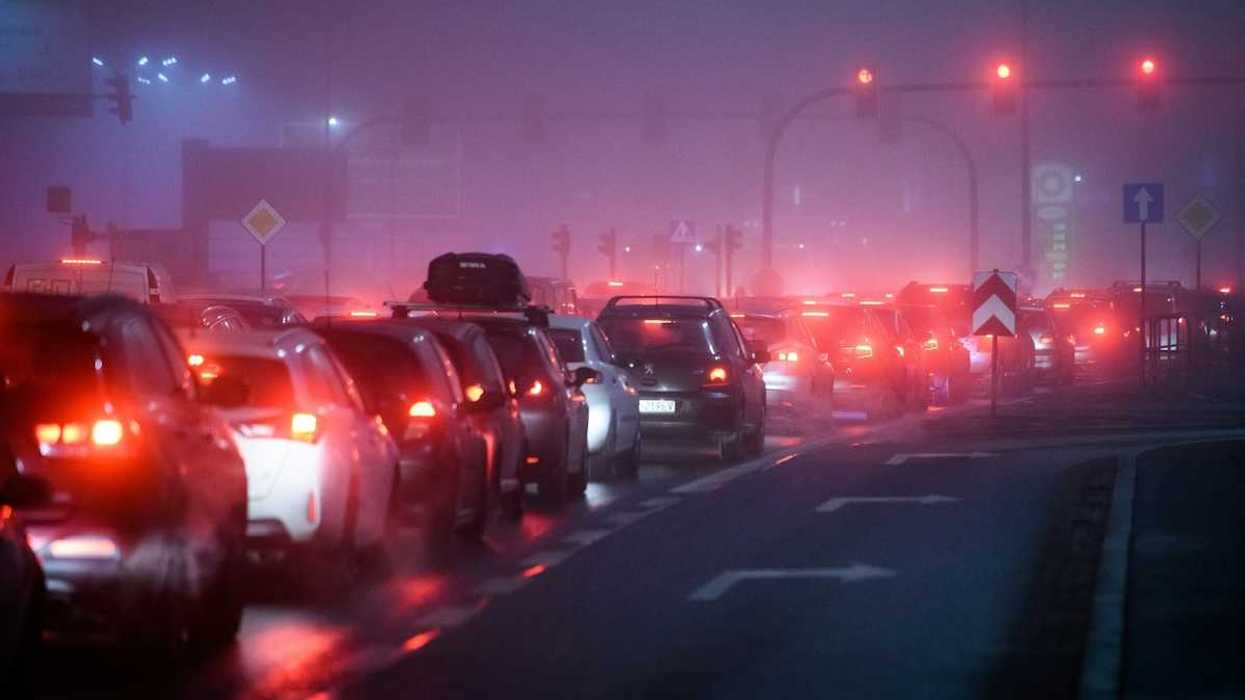 Traffic lined up at stoplight, idling and polluting