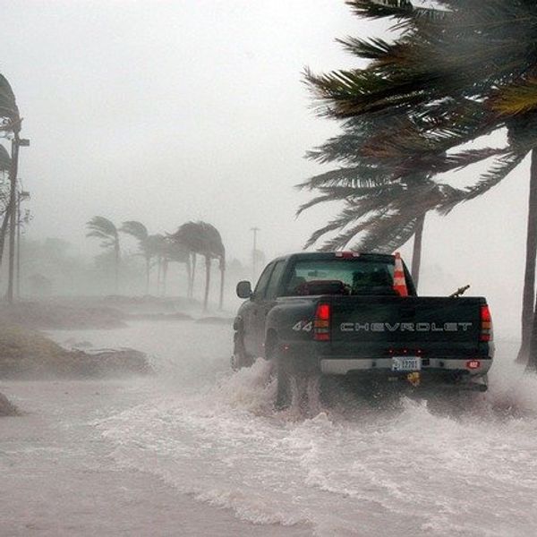 Truck driving through a flooded road during a hurricane.
