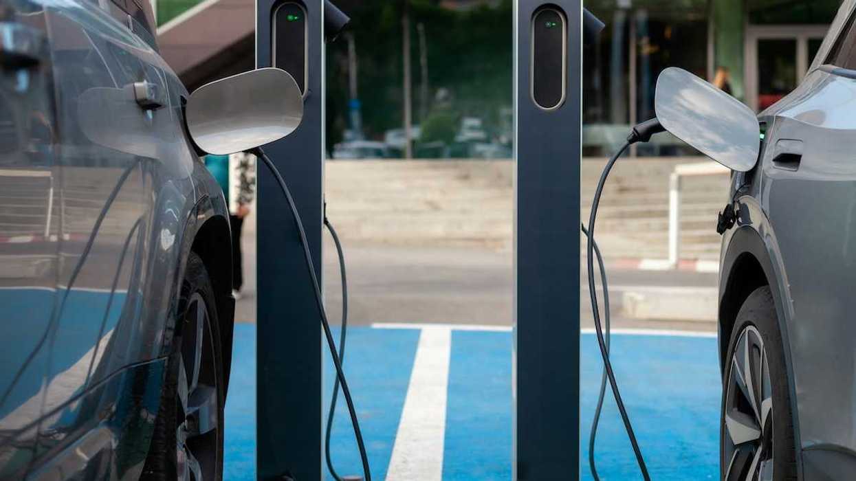 Two adjacent EVs being recharged at charging station.