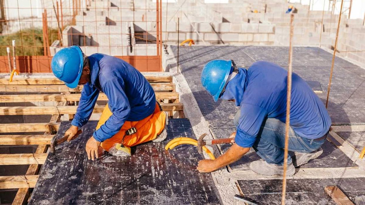 Two construction workers on a hot roof