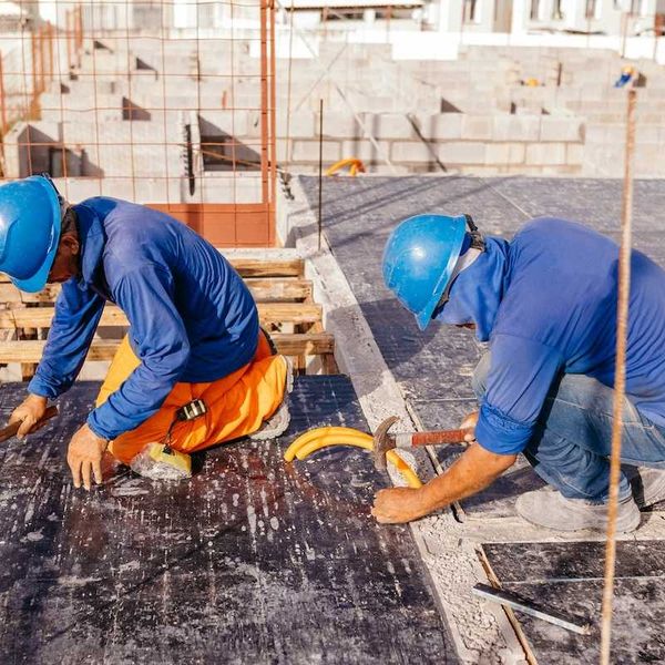 Two construction workers on a hot roof