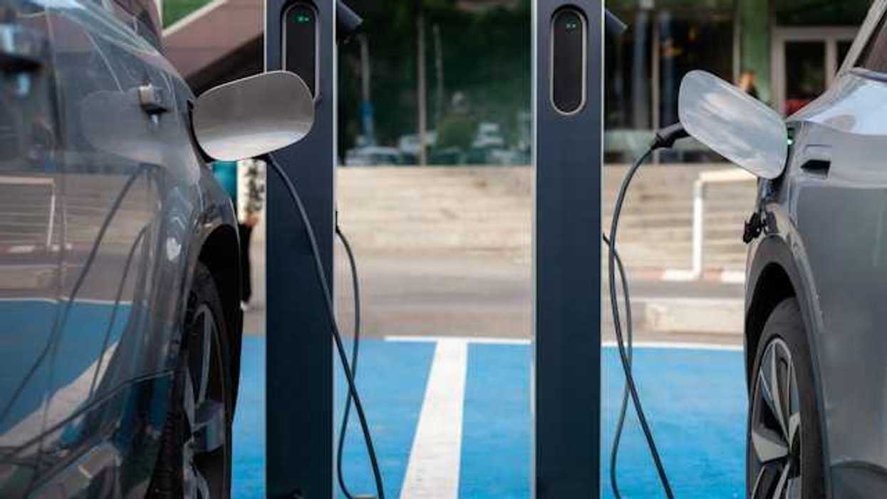 Two electric vehicles parked next to one another while being charged