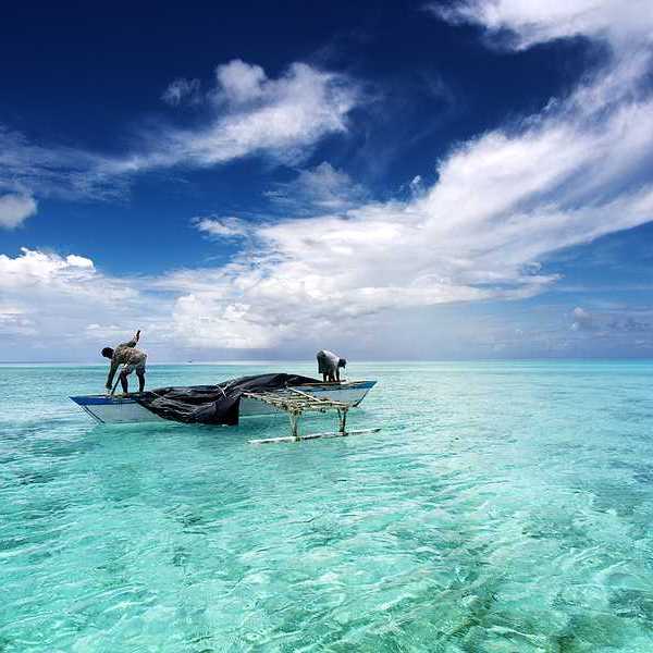 Two fishermen in a boat off a Pacific island
