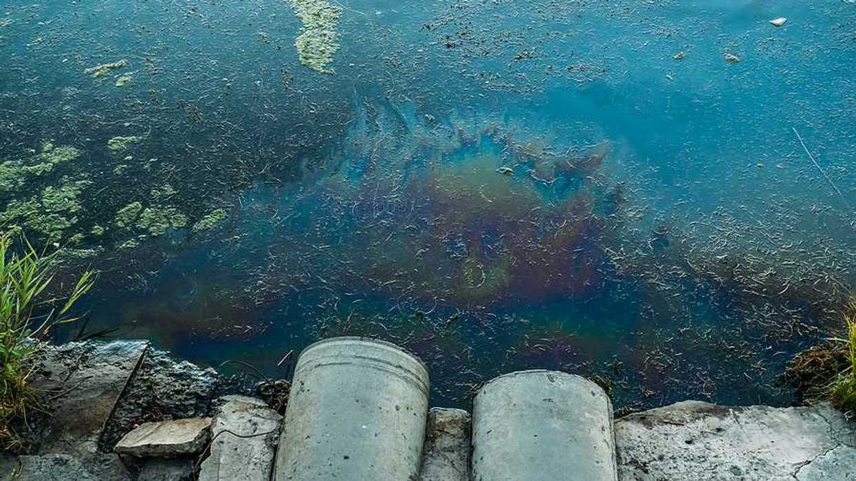 Two large pipes with dirty water flowing out of them