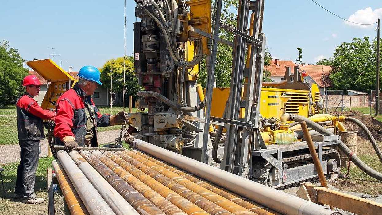 Two men drilling a geothermal well for a residential geothermal heat pump.