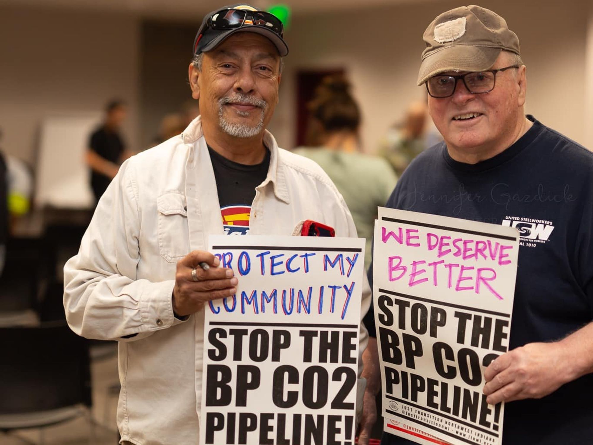 Two men holding signs protesting the BP CO2 pipeline