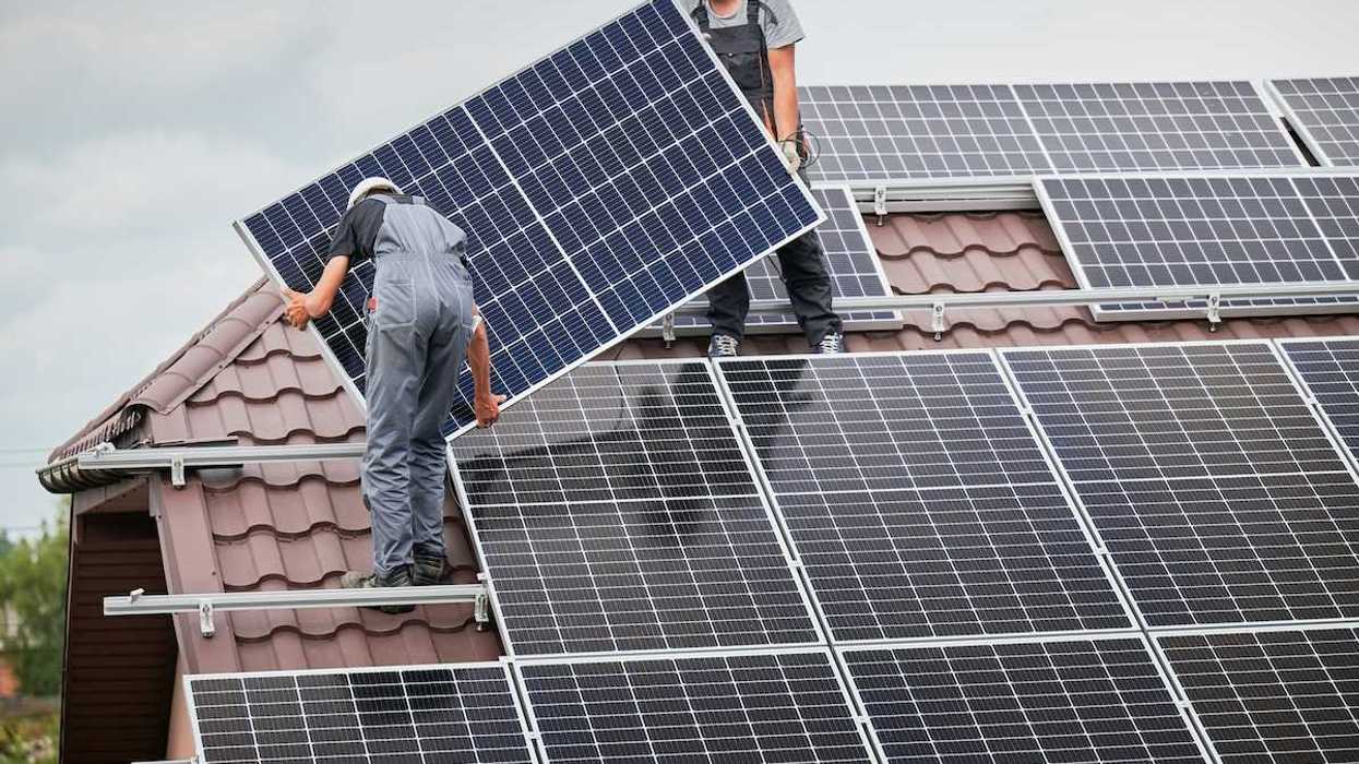 Two men installing residential solar panels