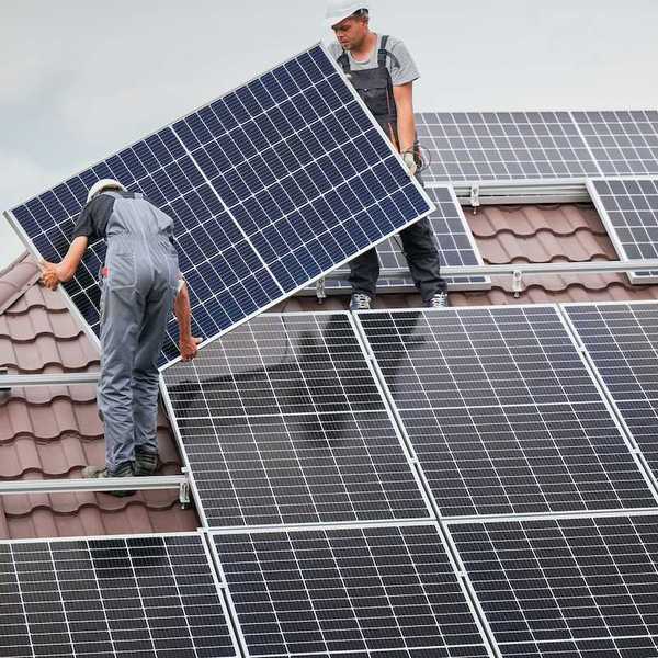 Two men installing residential solar panels