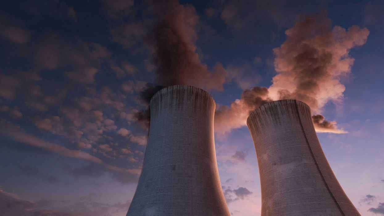 Two nuclear energy cooling towers against a sunset sky.
