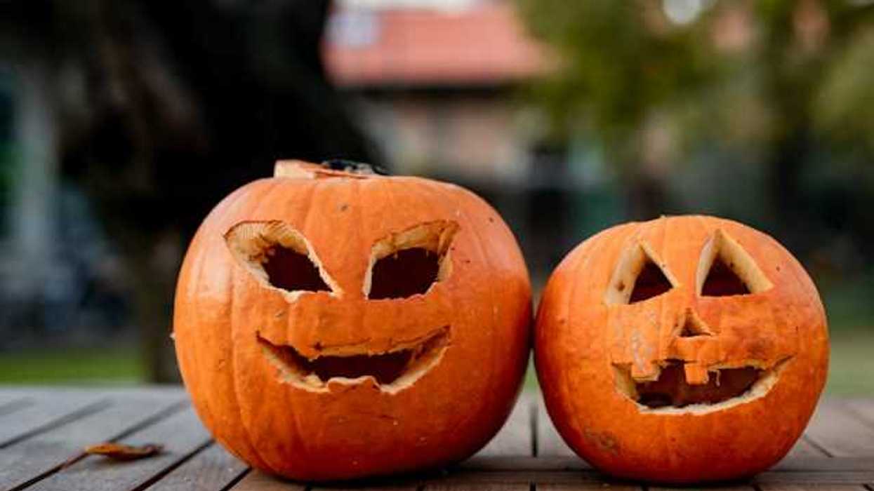 Two orange pumpkins with faces carved into them