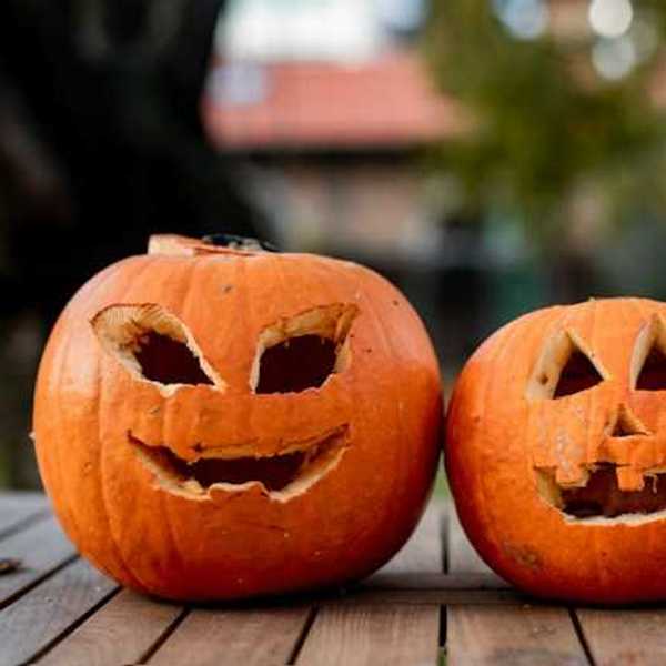 Two orange pumpkins with faces carved into them