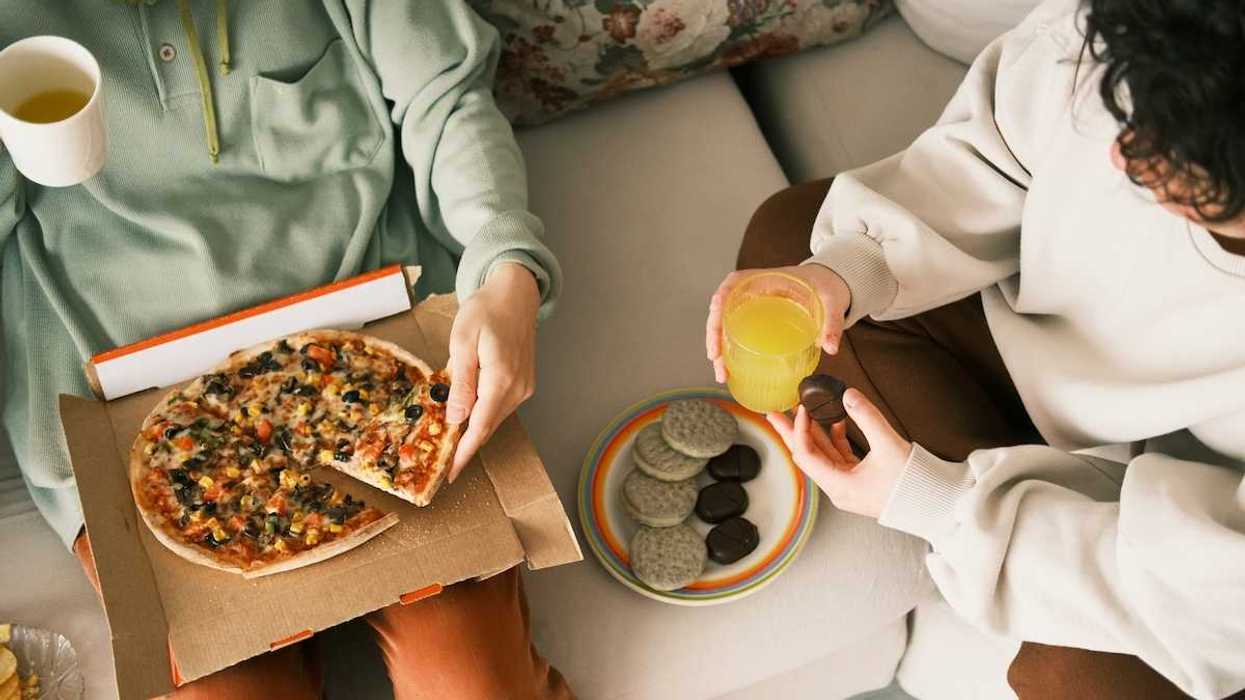 Two people dining on pizza and cookies