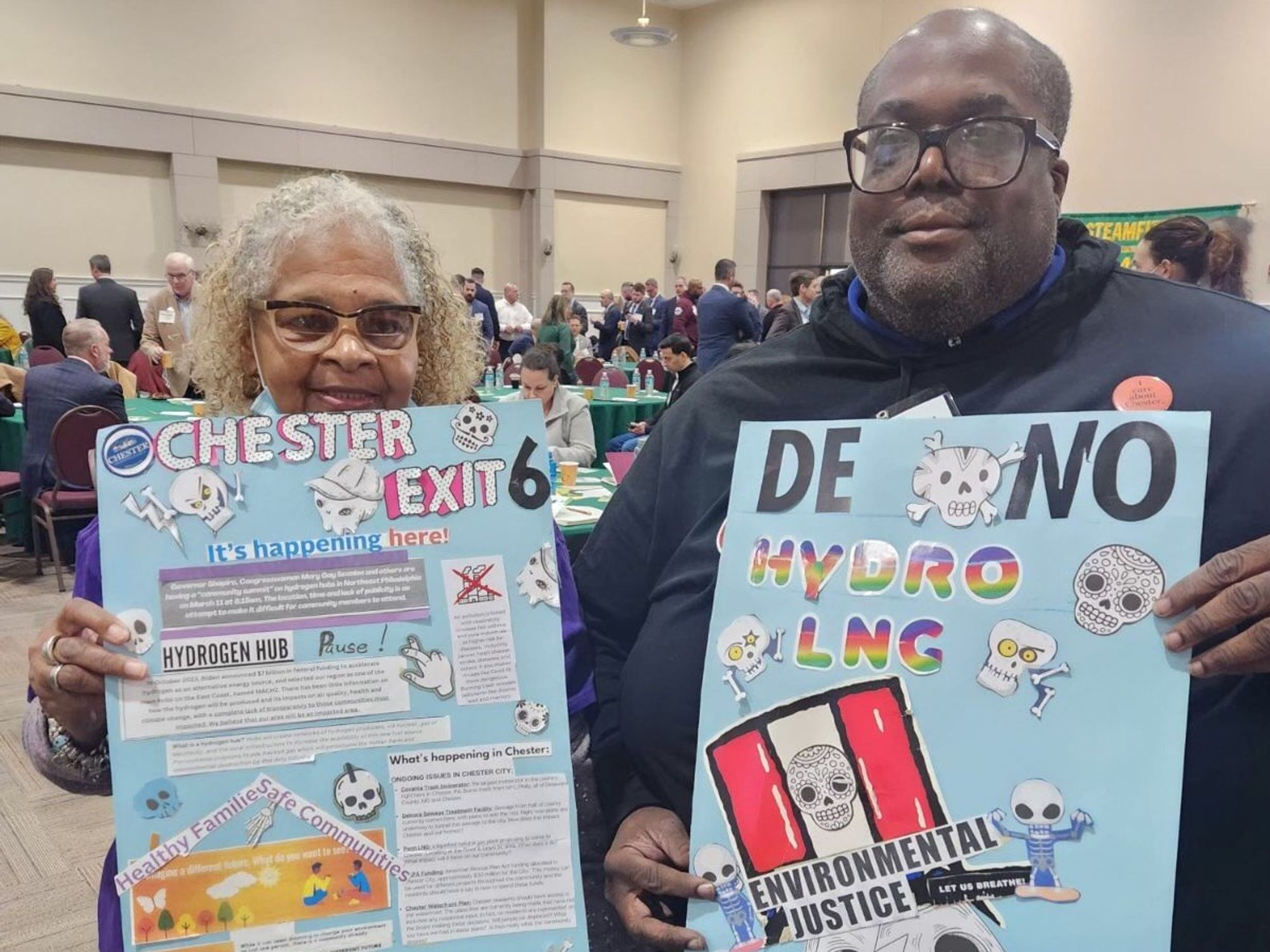 Two people holding signs against the Mid Atlantic hydrogen hub