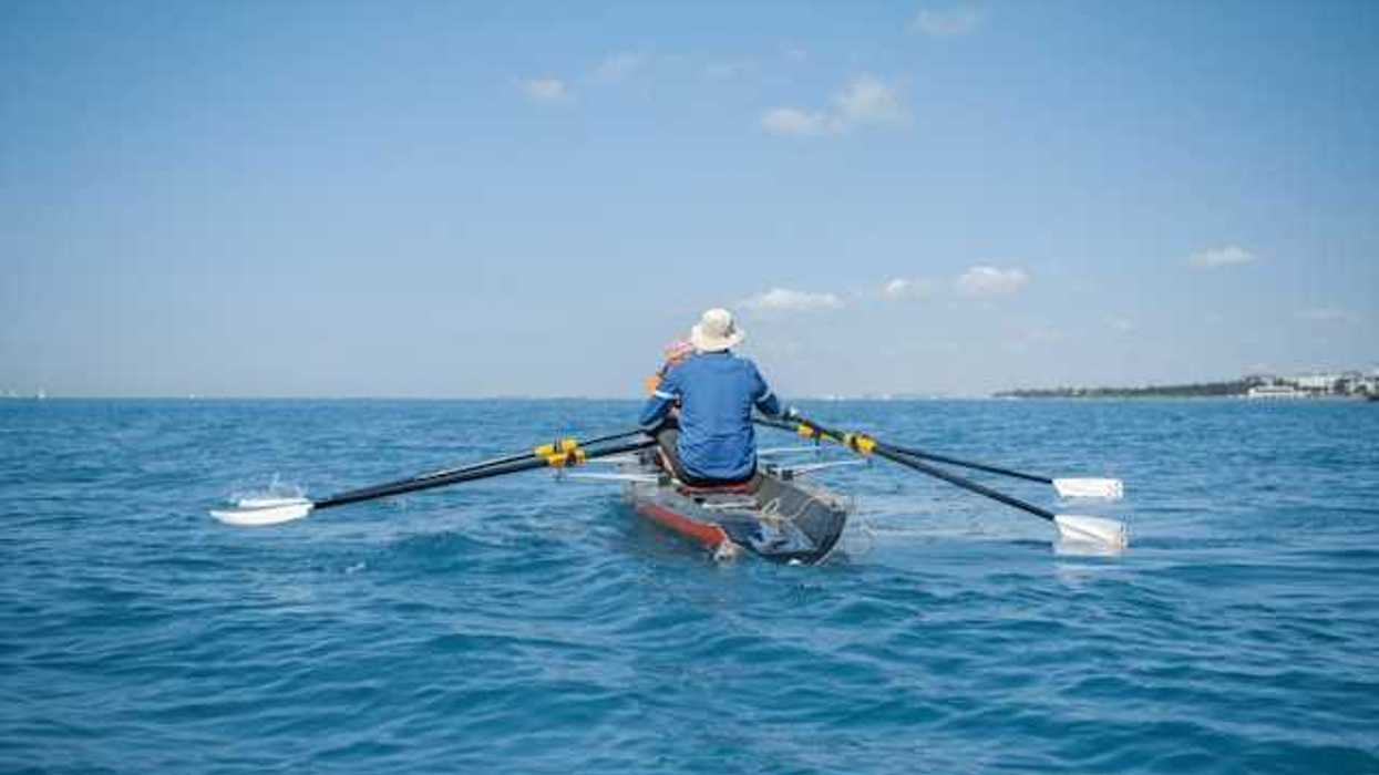Two people rowing on open water