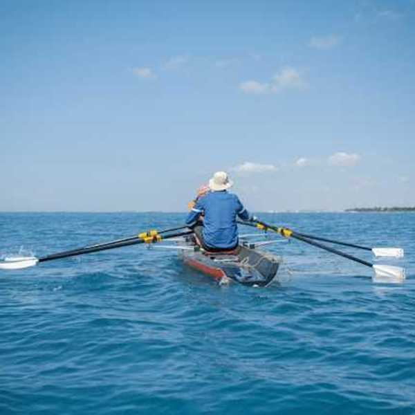 Two people rowing on open water