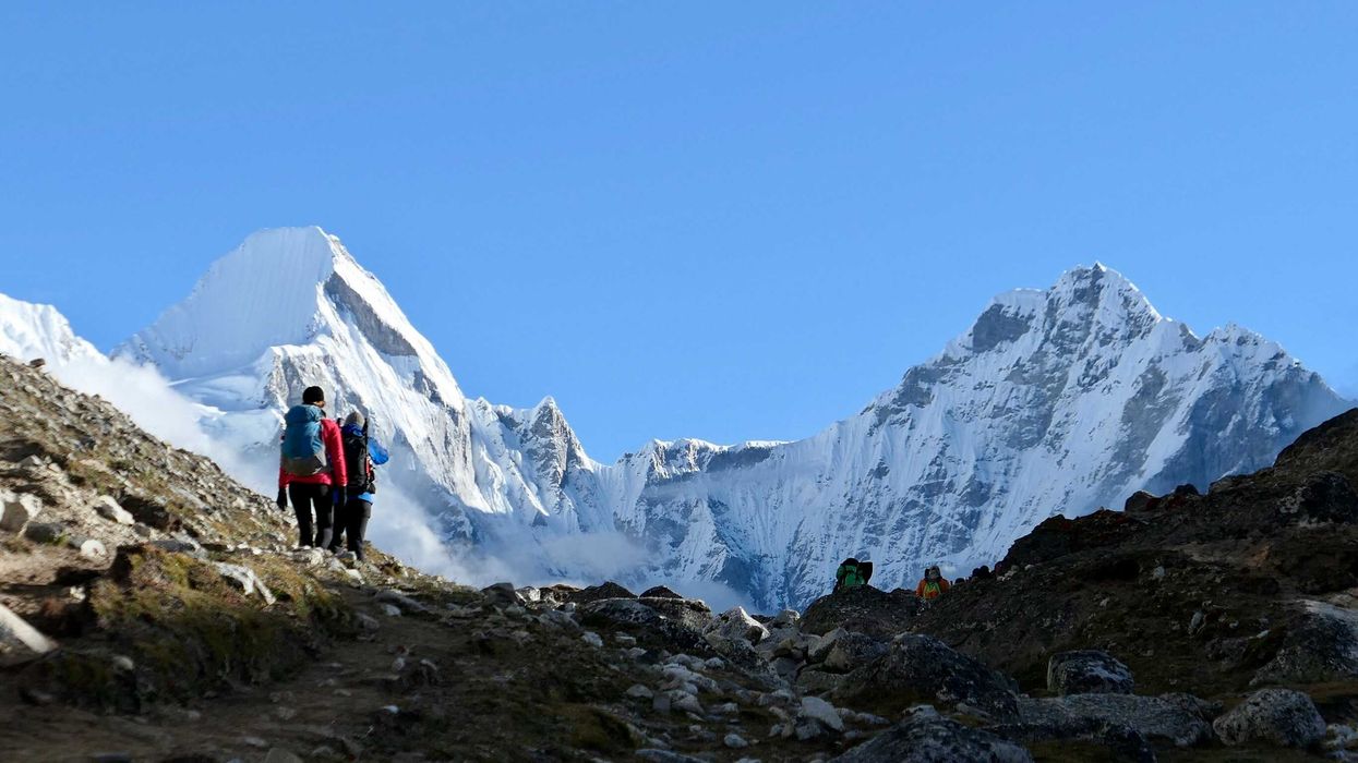 two person on mountain with snowy mountains in the background