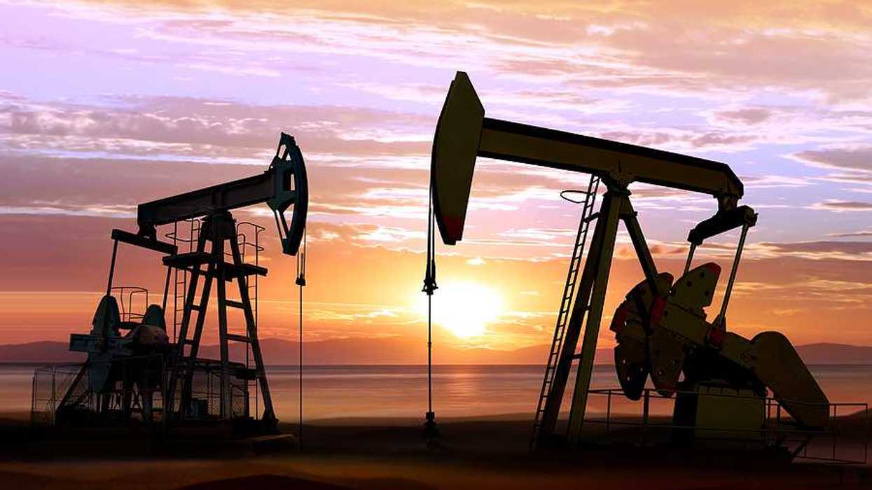 Two pump jacks against a sunset