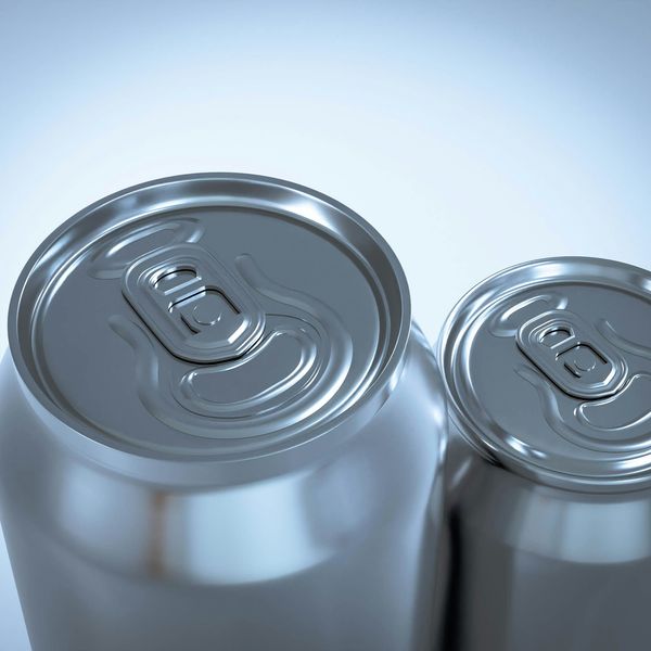 two silver soda cans sitting next to each other