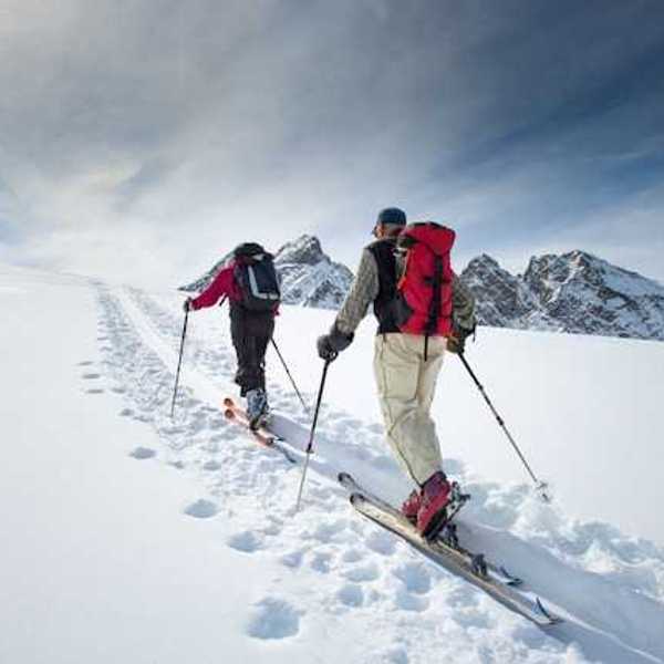 Two skiers moving up a snowy mountain