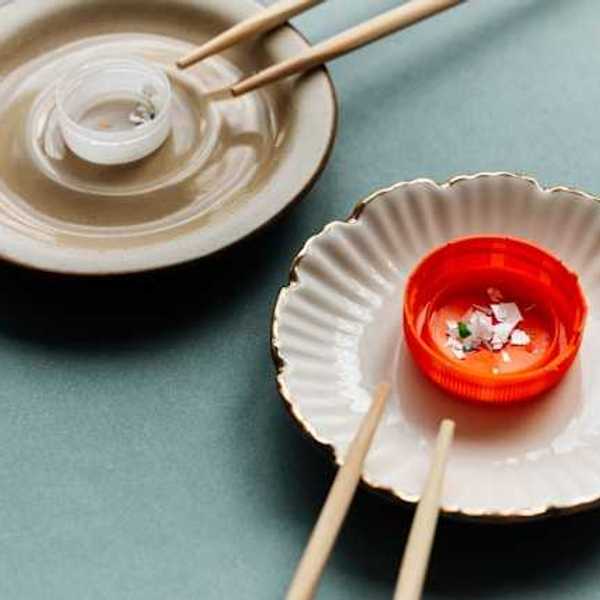 Two small dishes with plastic bottle caps and chopsticks