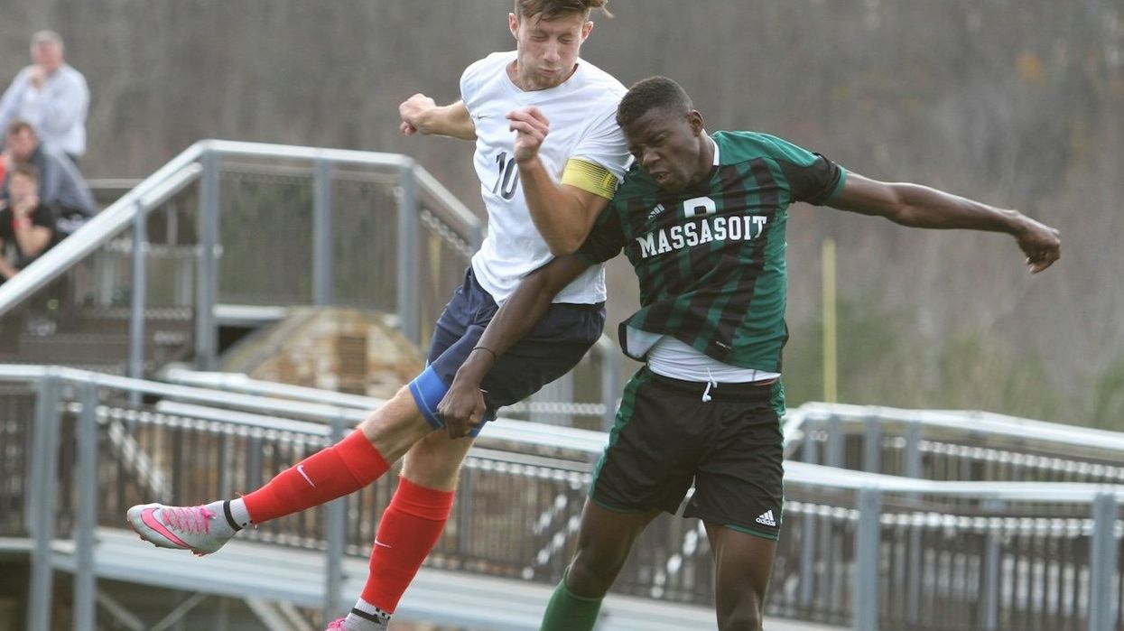 Two soccer players collide mid-air as the ball bounces off one of their heads.