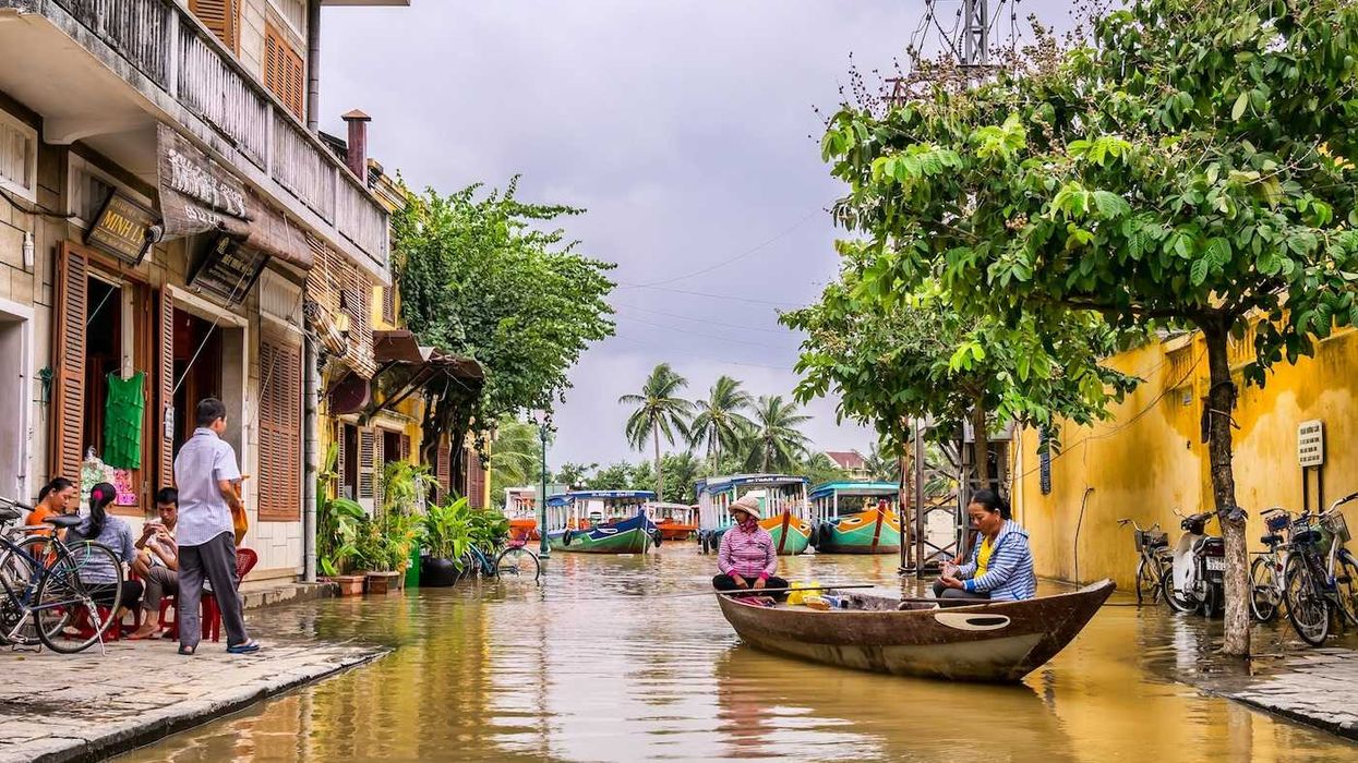 Two women in a boat on a flooded street in Vietnam