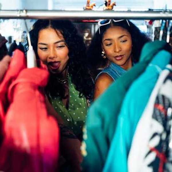 Two women of color looking at clothing on a rack