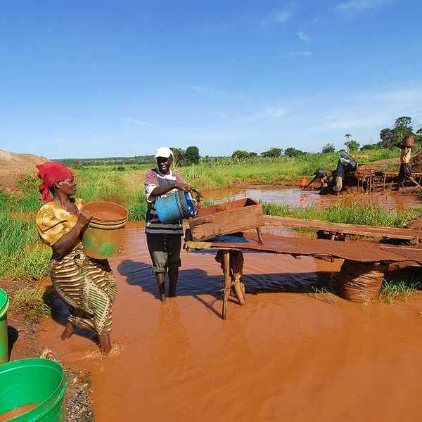 Two Zimbabweans pouring water into a mining ramp