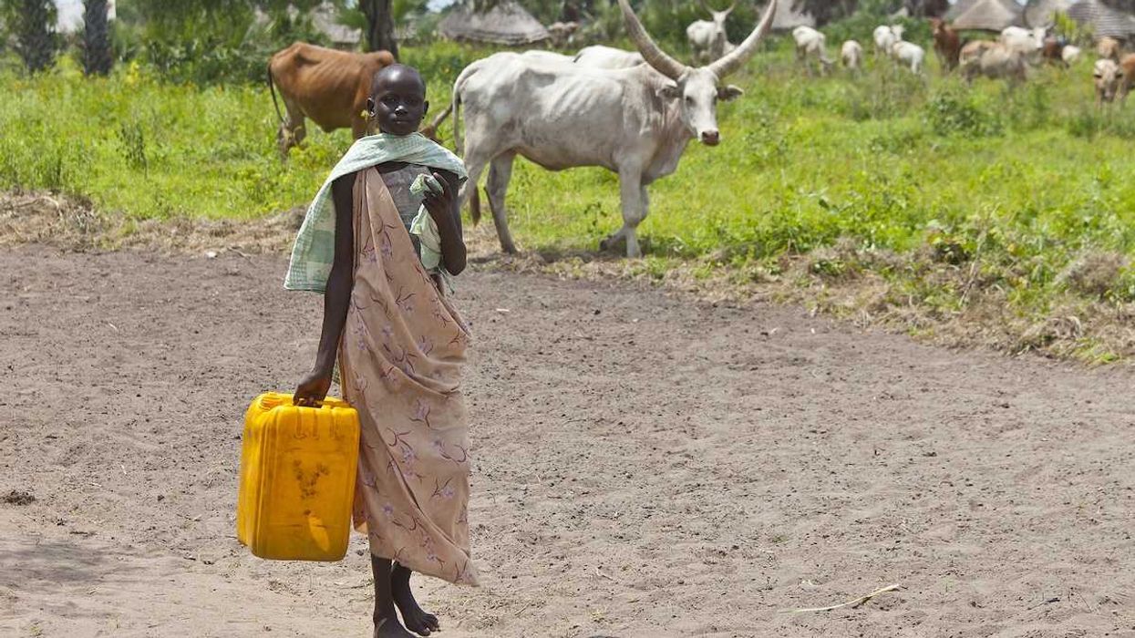 Unidentified woman carries a large water jug to get water from the Nile in South Sudan.