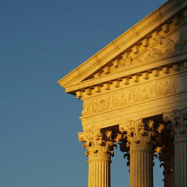 US Supreme Court roof and pillars in evening sun and shadow.