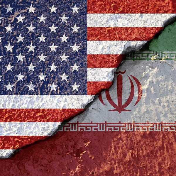 USA flag and Iran flag on cracked wall damage.