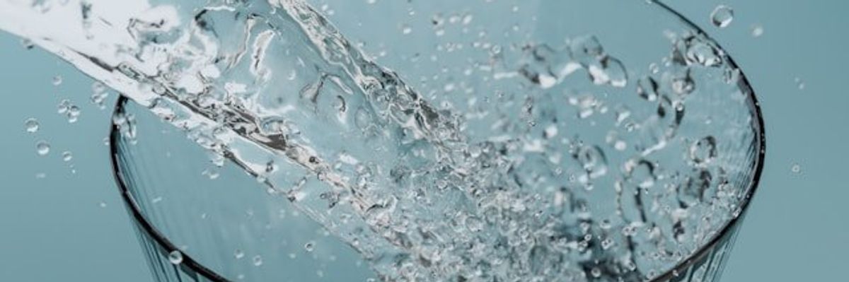 Water being poured into a glass of water.