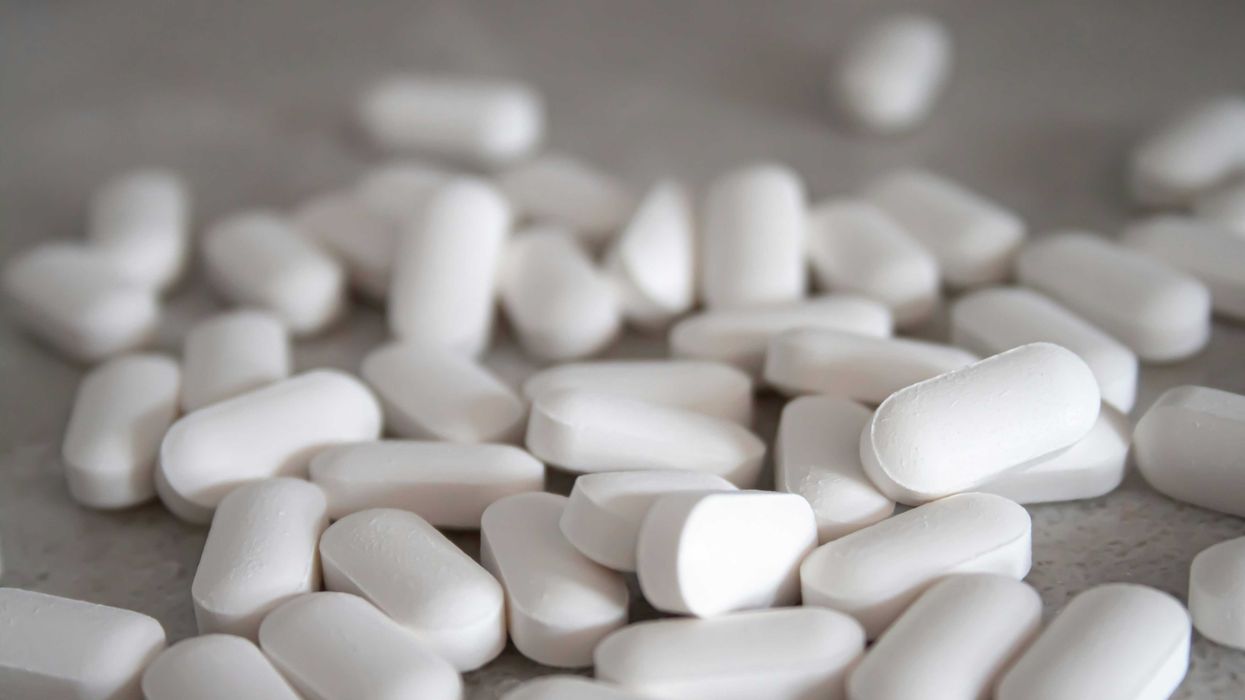 white acetaminophen pills spilled on gray surface.