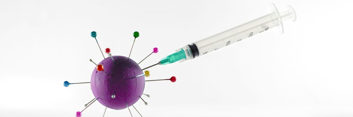 white and green syringe on white surface stuck into a purple ball.