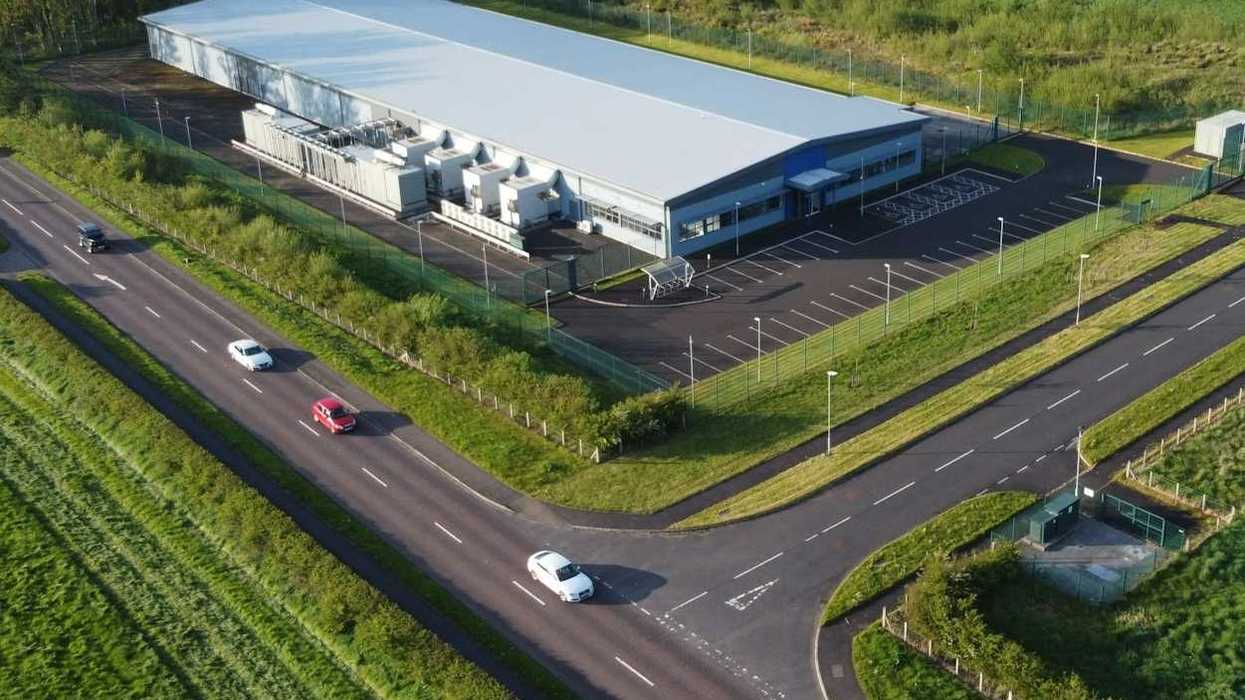 White-colored data center against green landscape.