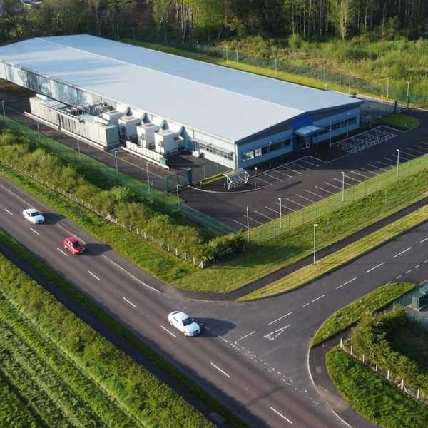 White-colored data center against green landscape.